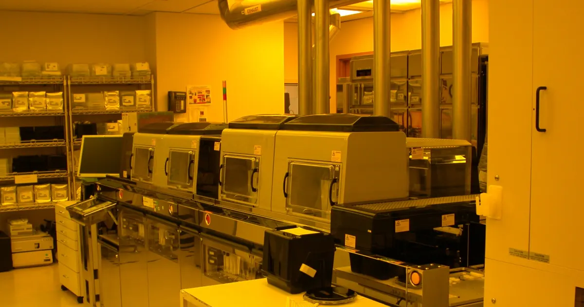 Automated wafer track system in a yellow-lit cleanroom with enclosed handling stations, a layout similar to the front end behind EFEM parts
