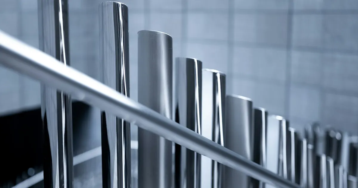 Bright polished metal tubes standing in a rack, the kind of smooth surface electropolishing 316L aims for